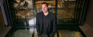 Dr. Jason Cryan stands in NHMU&#039;s exhibit