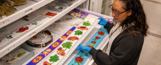 Olivera Masters examines a beaded belt in the Anthropology Collections