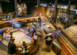Guests move around an interactive table in the museum
