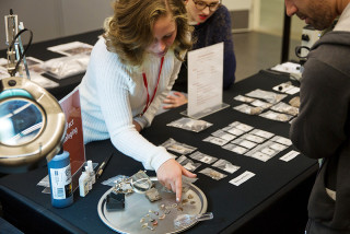 A museum intern shows a guest arrowheads.