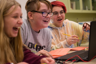 Children work at a computer. 