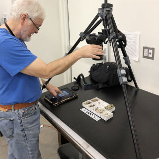 A volunteer photographs a fossil in the Museum's collections.