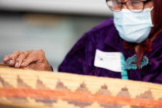 A Navajo elder touches a basket in collections at NHMU.