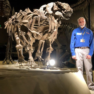 Fossil of Akainacephalus johnsoni with volunteer paleontologist 