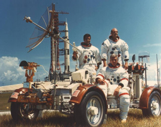 Astronauts pose for a photo on a buggy