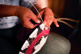 hands weaving a basket