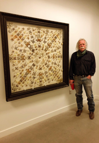 Curator Eric Rickart standing next to the case to show how large it is. Hanging on the wall about two feet off the ground, the top is taller than Eric. 