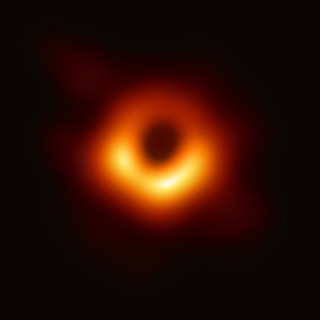 The first image of a black hole, an orange ring in space.
