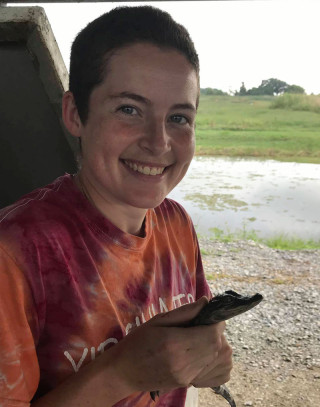 Emily in the field holding a small caiman.