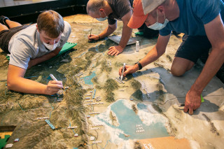 Team members from Creotrē add finishing touches to the new 3D map of Utah installed at NHMU. 