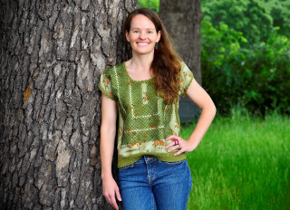 A portrait of Alexandra Ponette standing next to a tree. 