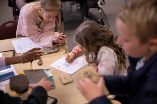 Three students investigate fossils in a Museum on the Move class