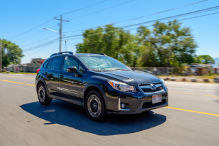 A car drives down the street with a sensor antenna rising from a passenger window.