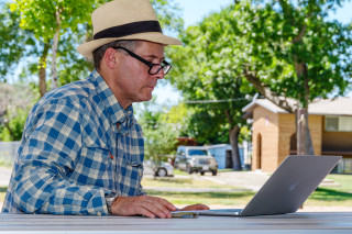 Rob Wilson works at a park bench. 