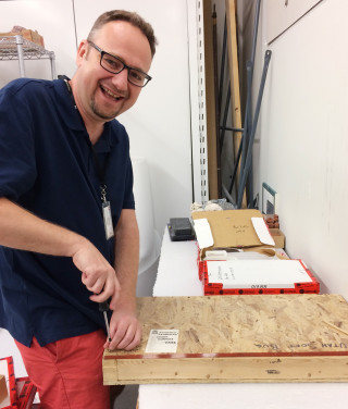 A scientist unboxes a fossil in collections at NHMU.