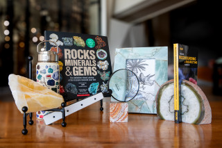 A selection of guests including geodes, handbooks for rockhounding, and a gems and mineral water bottle.