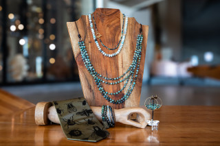 A selection of jewelry pieces, turquoise necklaces, and a silk tie.