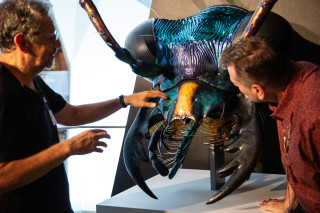 Fernando Sr. shows Jason Cryan details on the large tiger beetle model.