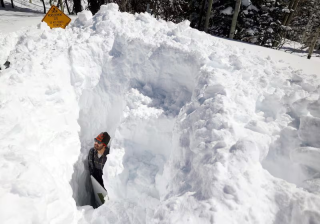 Dave Eiriksson, Hydrologist with the Natural Resources Conservation Service, standing in the snow to show the depth of the snowpack.