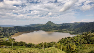 An elevated view looking down on a lake surrounded by jungle.