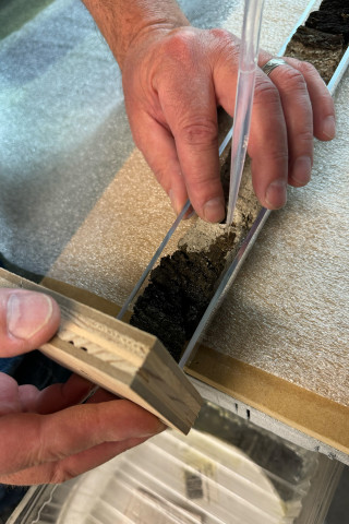 Hands work on preserving a lake core. 