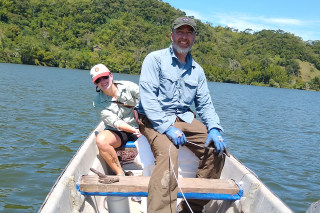 Two researchers on a boat collecting sediment cores from the Laguna-Maar de San Diego
