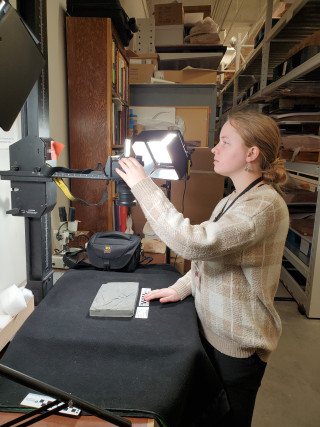 A Paleontology Collections Assistant photographs a fossil.