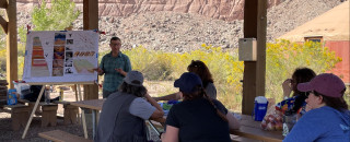 Teachers look at a presentation with red cliffs in the background