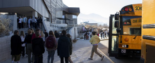 Students exit a bus to enter NHMU. 