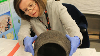 NHMU Volunteer Marla Wall works with a priceless artifact in the anthropology collections. 