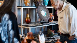 A guest shops pottery at the Indigenous Art Market