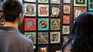 Guests look at paintings on sale at the market. 