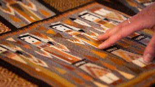 A guest examines a weaving featuring indigenous design.