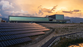 A modern office building surrounded by solar panels. 