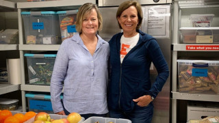 Two women stand in a kitchen for a photo.