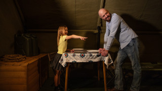 A father and daughter chat inside a mock tent in the Becoming Jane exhibit. 