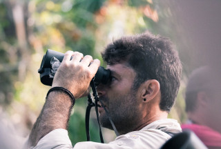 A man looks through binoculars