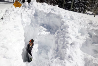 Dave Eiriksson, Hydrologist with the Natural Resources Conservation Service, standing in the snow to show the depth of the snowpack.