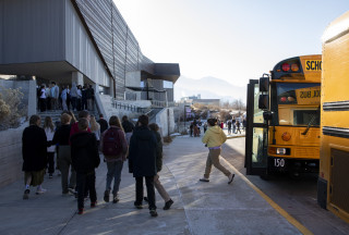 Students exit a bus to enter NHMU. 