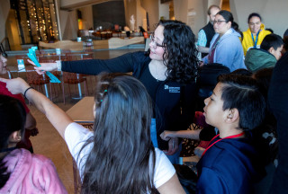 A staff member helps welcome students to NHMU