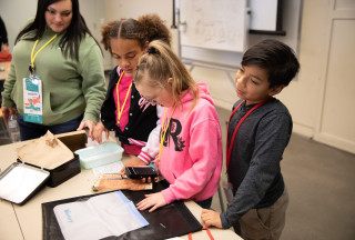 Students examine a radio in a classroom