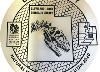 The Explorer Corps marker for Emery County featuring a dinosaur fossil.