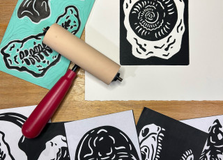 A series of hand printed images of fossils, a rubber stamp, and ink roller.