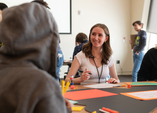 A young girl smiles while working on a science project.