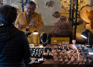 An artist sells jewelry at the museum