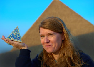 Sarah sits outside a pyramid