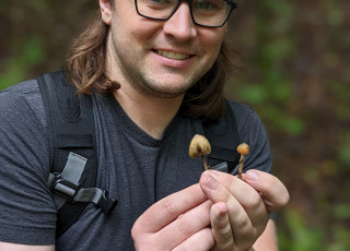a person holding mushrooms in his hands