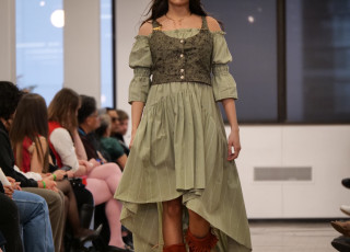 A young woman models a green garment with red boots