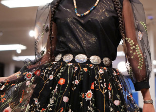 A young woman models a black and floral garment